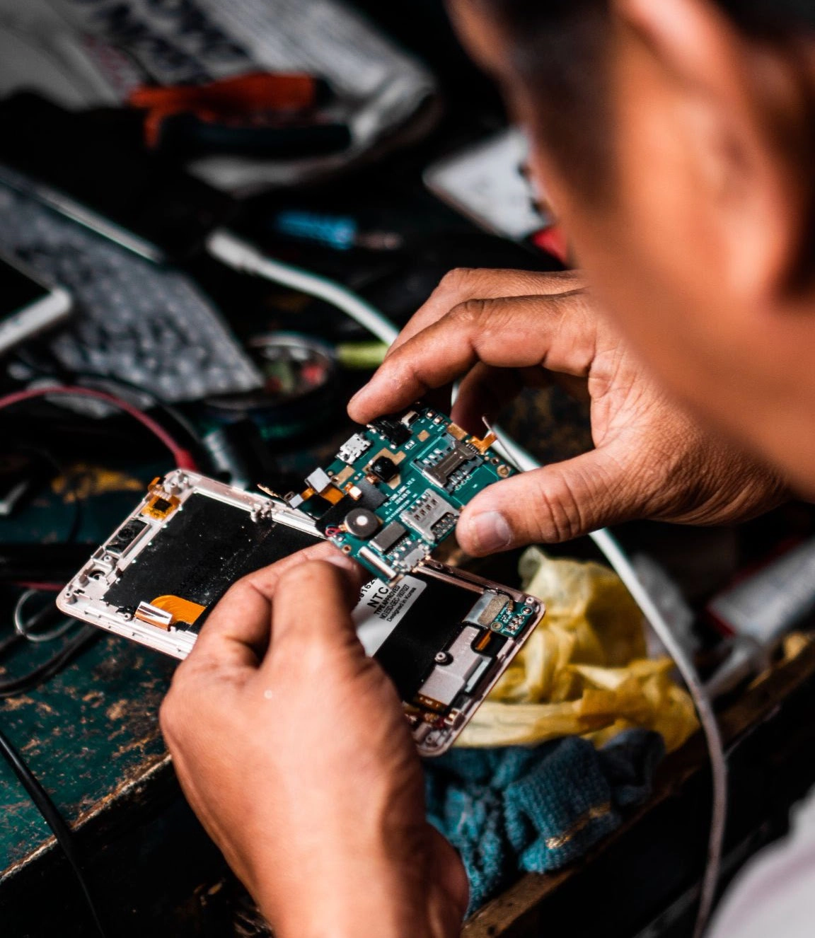 Technician holding a an open smartphone repairing the motherboard